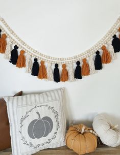 a white pillow sitting on top of a wooden table next to a pumpkin and other decorative items