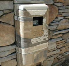 a stone wall with a mailbox on it