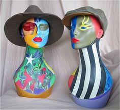 two colorfully painted vases sitting next to each other on a white surface,