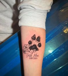 a person with a tattoo on their arm that has a dog's paw and name