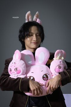 a woman holding three stuffed animals in her hands with bunny ears on their head and nose