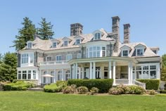 a large white house sitting on top of a lush green field