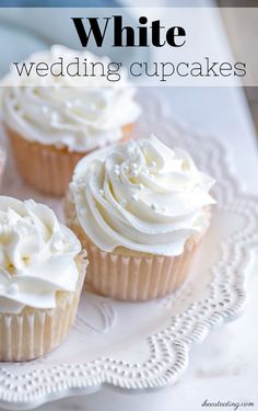 four cupcakes with white frosting on a plate