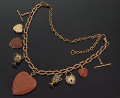 "Very rare fancy chain necklace with heart charm pendants C.1860. Be it Victorian era or nowadays heart is a very much loved symbol in jewelry. The necklace is 21 1/2\" long end to end. It consists of fancy finely ornate chain 12\" long 8 mm wide and finely ornate chain extender 9 1/2\" long 4 mm wide. The 9 charm pendants are: 1. Fancy gold filled 26 mm long twisted T-bar (19 mm high with chain) 2. 2-picture heart locket 19 mm X 17 mm. The front and back are 9K gold, gold filled interiors. The Antique Necklace With Vintage Charm For Valentine's Day, Collectible Yellow Gold Necklace With Heart Charm, Victorian Antique Gold Necklaces For Valentine's Day, Victorian Antique Gold Necklace For Valentine's Day, Victorian Heart Charms Jewelry, Victorian Antique Gold Heart Pendant Necklace, Victorian Heart-shaped Charms Jewelry, Antique Bronze Necklace For Valentine's Day, Antique Heart Pendant Necklaces With Vintage Charm