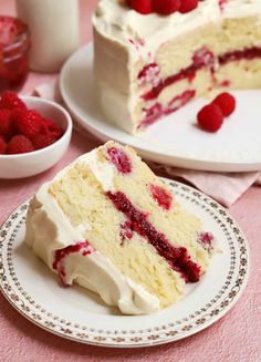 there is a piece of cake with white frosting and raspberries on it