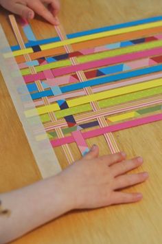 a person is cutting out strips of colored paper