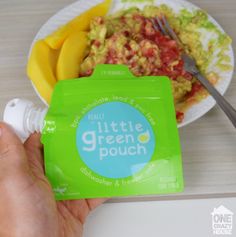 a person holding a green pouch next to a plate of food