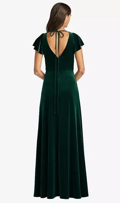 a woman wearing a green velvet dress with open back and tie at the neckline