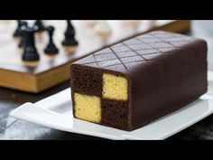 a piece of cake sitting on top of a white plate next to a chess board