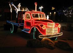 an old red truck decorated with christmas lights