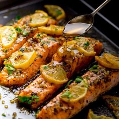 the salmon is being cooked with lemons and herbs