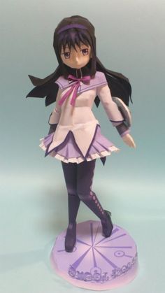 a figurine that is on top of a purple base and has long black hair