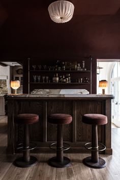 a bar with three stools in front of it