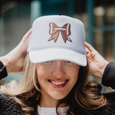 Kick off your game day style with our Football Bow Coquette Patch Foam Trucker Hat! Available in classic black or crisp white, this foam hat combines sporty charm with feminine flair. The standout feature is the adorable patch showcasing a bow with a playful football print, adding a touch of whimsy to your look. Whether you're cheering on your favorite team from the sidelines or running errands around town, this hat is the perfect accessory to show off your love for the game. Get ready to score major style points with our Football Bow Coquette Patch Foam Trucker Hat! 65% cotton, 35% polyester machine wash delicate or hand wash one size fits most adjustable back mesh netting snapback closure Adjustable White Hat With Bow, White Flat Brim Trucker Hat For Game Day, White Adjustable Trucker Hat For Game Day, Adjustable White Hat For Game Day, Towel Scarf, Tie Dye Hat, Trendy Hat, Hat Patches, Football Mom