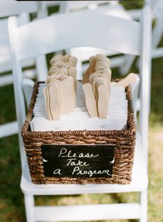 there is a wicker basket on the back of a white chair with napkins in it