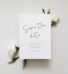 the save the date card is surrounded by white flowers and greenery on a table