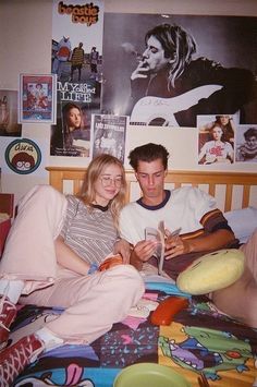 a man and woman sitting on a bed together