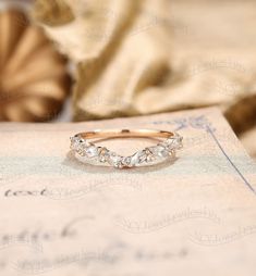 a close up of a wedding ring on top of a piece of paper with an object in the background