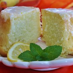 two pieces of cake on a plate with lemon and mint