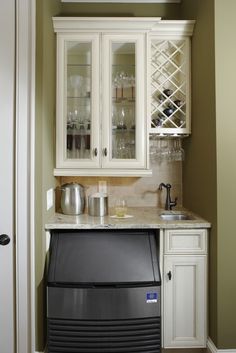 a kitchen with white cabinets and marble counter tops