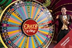 a man in a tuxedo standing next to a wheel of fortune sign with the words crazy time on it