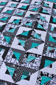 a black and white quilt with teal accents