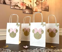 three bags with minnie mouse ears on them sitting on a table in front of a wall