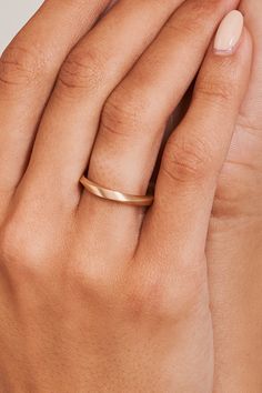 a woman's hand with a gold ring on top of her left hand,