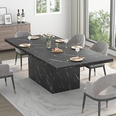 a black marble dining table surrounded by grey chairs and white rugs in front of large windows