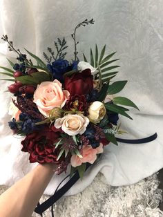 a bridal bouquet with red, white and blue flowers on top of a blanket