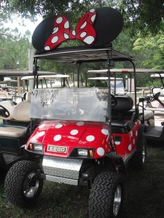 a red and white golf cart with minnie mouse ears on it