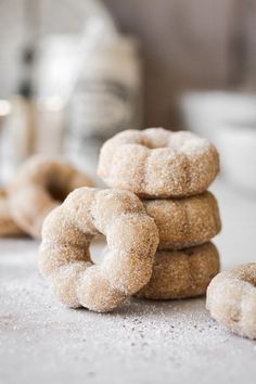 some sugared donuts are stacked on top of each other and ready to be eaten