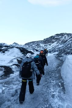 several people walking up a snow covered hill