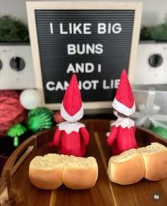 two little red elves sitting on top of buns