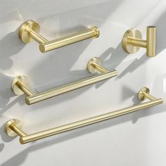 three brass bathroom hardware on a white background