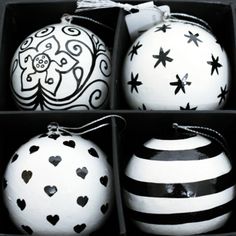 four black and white ornaments in a box