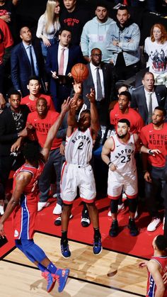 a group of men standing on top of a basketball court next to each other in front of a crowd