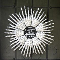 a happy halloween wreath made out of white hands