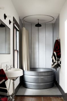 a bathroom with a tub, sink and mirror