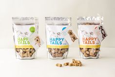 three bags of happy tails dog treats sitting next to each other on a white surface