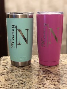 two tumblers sitting on top of a counter next to each other, one pink and one blue