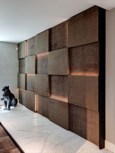 a dog sitting on top of a white counter next to a wooden paneled wall