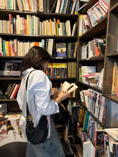 a woman standing in front of a bookshelf filled with lots of different types of books