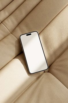 a cell phone laying on the back of a couch with a blank screen attached to it