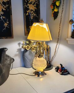 a lamp sitting on top of a table next to a vase and figurines