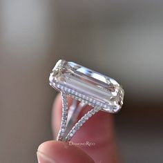 a close up of a person holding a diamond ring