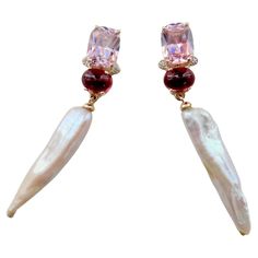 Pink zircon (origin: Sri Lanka) of cushion shape and "Conch Shell" pink color are paired with cabochon Rhodolite garnets and diamonds in these dangle earrings. Completing the composition are a pair of highly unusual stick pearls (origin: Japan). They possess metallic luster and are delicate creamy/white in color. These one-of-a-kind dangle earrings are created in 18k yellow gold and have posts and heavy weight friction backs. Diamond Star Earrings, Pink Zircon, Turquoise Earrings Dangle, Shell Pink, Metallic Luster, Diamond Dangle Earrings, Diamond Star, Rhodolite Garnet, Conch Shell