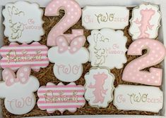 some decorated cookies in a box with numbers and minnie mouses on them are ready to be eaten