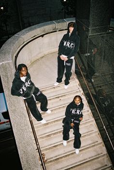 three young men are standing on the steps