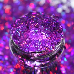 a jar filled with purple glitter sitting on top of a table